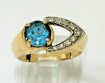 Beautiful ladies' 14kt yellow gold V shape cocktail ring set with natural round 7mm blue topaz gemstone holding .20ct brilliant cut diamonds