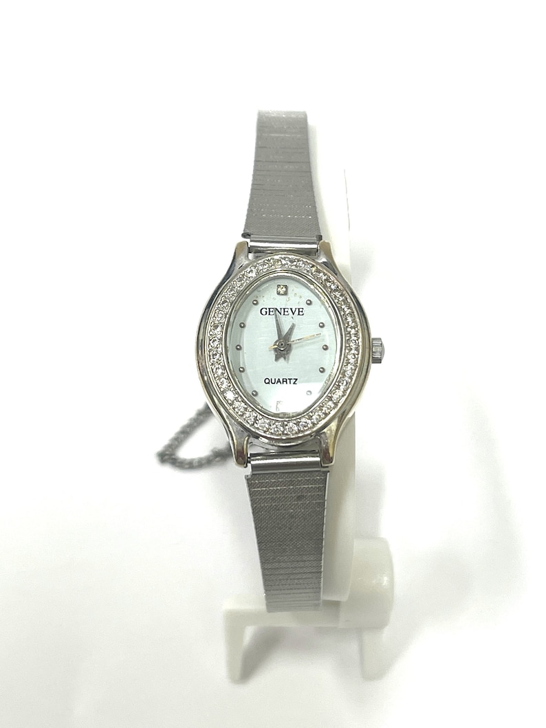 Ladies vintage 18K white gold Geneve oval shaped quartz movement watch set with round diamonds and mesh type stainless steel band. image 1