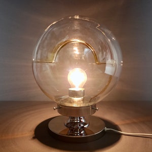 Murano art glass Space Age Mazzega 1970s table lamp in blown clear glass with amber-colored inclusions and chrome base.