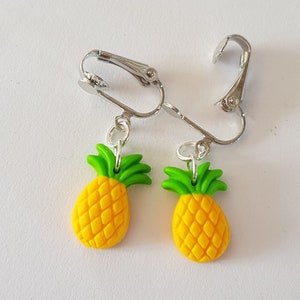 May include: A pair of silver clip-on earrings with yellow and green pineapple charms.