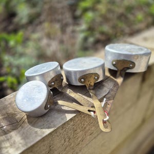May include: A set of three ceramic mugs with a speckled, matte finish in cream, light grey, and dark grey. Each mug has a simple, minimalist design and a rounded handle.