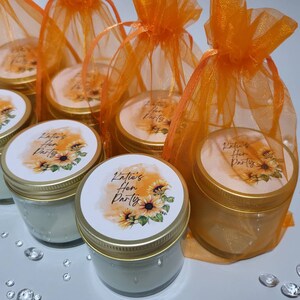 Puede incluir: Conjunto de seis peque&ntilde;os frascos de vidrio con tapas doradas y etiquetas personalizadas. Las etiquetas presentan un dise&ntilde;o de girasol y el texto "Katie's Hen Party". Los frascos est&aacute;n empaquetados en bolsas individuales de tul naranja.