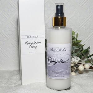 Może przedstawiać: Biała butelka sprayu do pomieszczeń o zapachu piernika z złotą nakrętką i etykietą z napisem "Elisewax Gingerbread Scented Room Spray Alcohol Free Base 200ml Made in Great Britain".