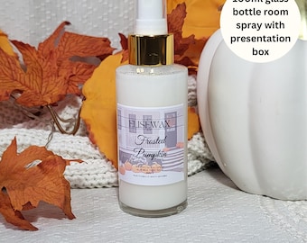 May include: A 100ml glass bottle of room spray with a white label that says "Elisewax Frosted Pumpkin" and a decorative design of pumpkins and a plaid pattern. The bottle is sitting on a white surface with fall leaves and a white pumpkin.
