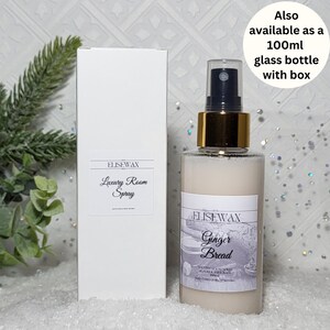 Może przedstawiać: Biała butelka ze złotą zakrętką i białą etykietą z napisem "ELISEWAX Ginger Bread" i "Luxury Room Spray". Butelka stoi na białym tle z zieloną rośliną w tle.
