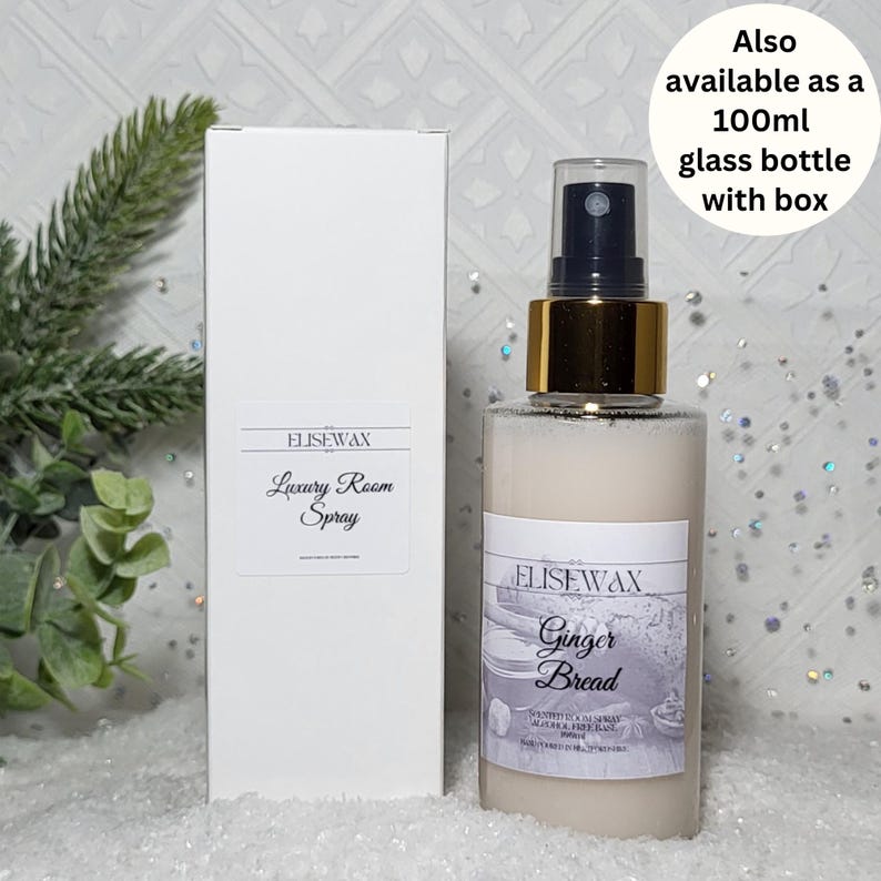 Może przedstawiać: Biała butelka ze złotą zakrętką i białą etykietą z napisem "ELISEWAX Ginger Bread" i "Luxury Room Spray". Butelka stoi na białym tle z zieloną rośliną w tle.