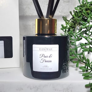 Luxury scented reed diffuser in emerald glass bottle Pear and Freesia home fragrance product Scented round glass diffuser with black reeds