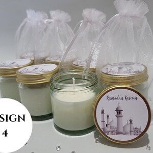 May include: Set of six small glass jars with gold lids and white candles. Each jar has a white label with a mosque design and the text "Ramadan Kareem". The jars are displayed on a white surface with white tulle bags.