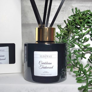 Luxury scented reed diffuser in an emerald glass bottle Caribbean teakwood home fragrance product Scented glass diffuser with black reeds