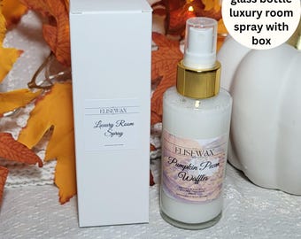 May include: A 100 ml glass bottle of room spray with a white label that says "ELISEWAX Pumpkin Pecan Waffles" and a white box with a label that says "ELISEWAX Luxury Room Spray".