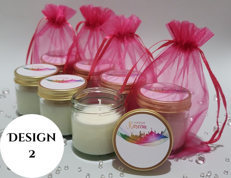 May include: Set of six small glass jars with white candles and gold lids. The jars are decorated with colorful labels that say "Ramadan Kareem". The jars are packaged in pink organza bags.