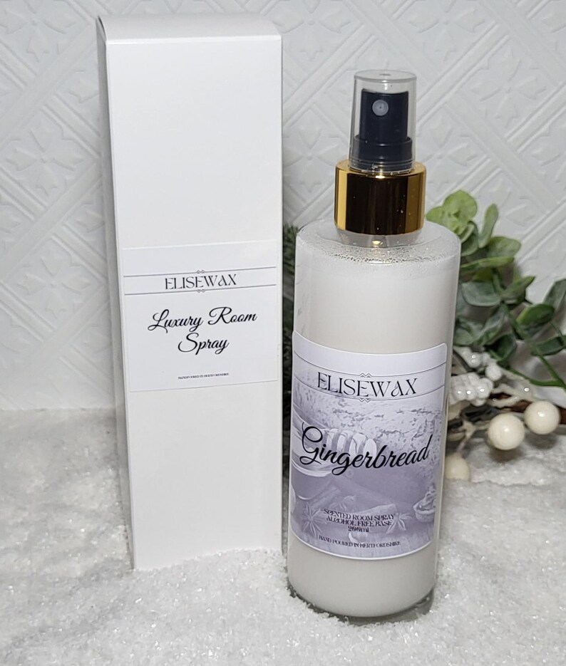 Może przedstawiać: Biała butelka ze złotą nakrętką i białą etykietą z napisem "Elisewax Gingerbread Scented Room Spray Alcohol Free 200ml". Butelka stoi na białym tle.