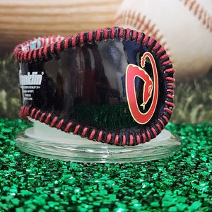 May include: Black baseball with red stitching and a red snake logo with the word "Franklin" printed on the side.