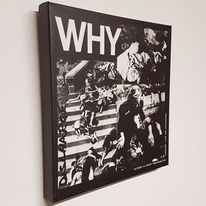 May include: Black and white canvas art piece with the word "WHY" in large, bold letters. The artwork features a collage of black and white images, with text that reads "CONQUEST LIVES ARE SQUANDERED IN ORDER TO SATISFY THEIR MANIA FOR".