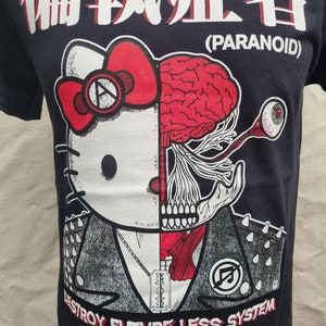 May include: Black t-shirt with a white graphic of a Hello Kitty character with a skull and brain on the right side of its face. The graphic also includes a razor blade, a chain, and the text "Destroy Future Less System". The text "Paranoid" is printed in white above the graphic.