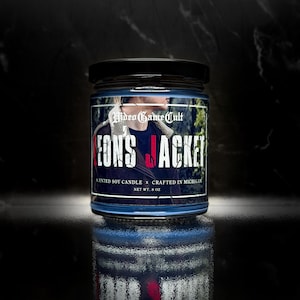 May include: A blue-tinted glass jar with a black lid. The label reads "Video Game Cult" and "Leon's Jacket." The candle is a scented soy candle, net weight 8 oz. The label features a person wearing a jacket.