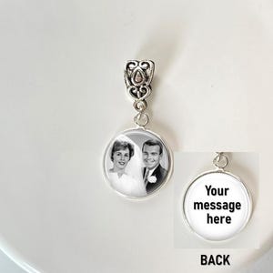 May include: A silver-toned circular pendant featuring a black and white photograph of a couple on the front. The pendant has an ornate, filigree-style bail at the top. The back of the pendant is white with the black text, Your message here.