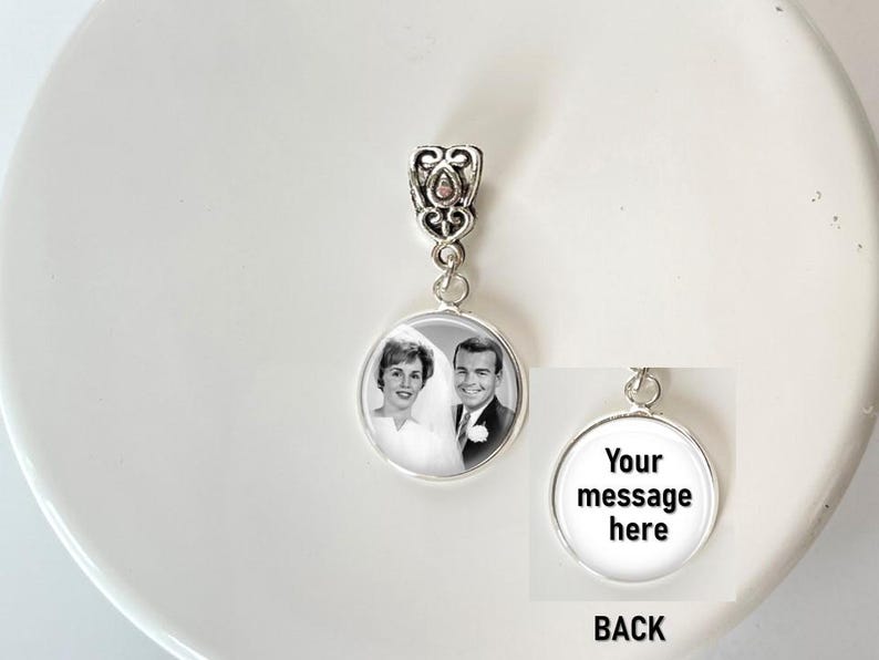 May include: A silver-toned circular pendant featuring a black and white photograph of a couple on the front. The pendant has an ornate, filigree-style bail at the top. The back of the pendant is white with the black text, Your message here.