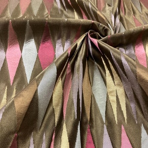 May include: Brown fabric with a diamond pattern in shades of pink, beige, and grey. The fabric has a subtle sheen and a soft texture.