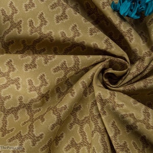 Może przedstawiać: Zbliżenie beżowego materiału z brązowym wzorem. Materiał jest złożony i udrapowany, co ukazuje fakturę i szczegóły wzoru.