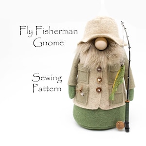 Op de afbeelding: Een vilten gnome die een bruin jasje draagt, een groene hoed en een hengel vasthoudt. De gnome heeft een lange witte baard en houdt een groene vis vast. De tekst "Fly Fisherman Gnome Sewing Pattern" staat boven de gnome.