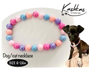 May include: A colorful beaded dog or cat necklace with pink, blue, and purple beads. The necklace is 6-26 inches in length. The text "KASHKAS FUR MAMA MADE" is visible in the top right corner of the image. The text "Dog/cat necklace SIZE 6-26 IN" is visible in the bottom left corner of the image.