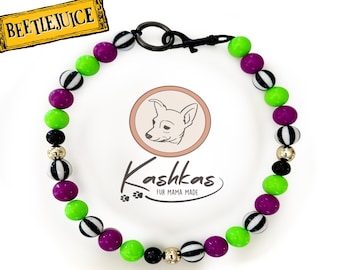 Könnte beinhalten: Ein Haustierhalsband aus Perlen mit einem wiederkehrenden Muster aus limettengrünen, violetten, schwarz-weiß gestreiften sowie einfarbig schwarzen und goldfarbenen Metallperlen. Das Halsband verfügt über einen schwarzen Metallverschluss.