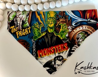 May include: A colorful dog bandana with a vintage monster movie theme. The bandana features images of Frankenstein, Dracula, and the Mummy. The text "Monsters" is printed in red and yellow letters.