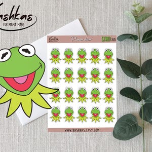 May include: A sheet of Kermit the Frog stickers and a large Kermit sticker. The stickers are green with yellow collars and smiling faces. The sheet has the text "Planner decor" and "Kashkas" with a website address.
