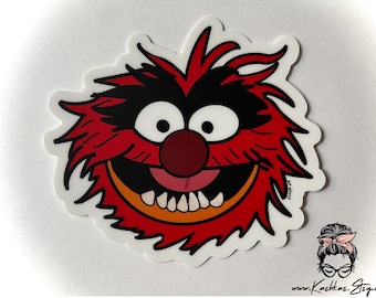 May include: A red and black cartoon character with a big smile and sharp teeth. The character has a large, red nose and a white background.