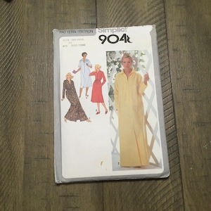 May include: Simplicity sewing pattern 904R for a long robe with a zipper closure. The pattern includes three different styles: a robe with a floral print, a red robe, and a yellow robe. The pattern is for petite, miss, and women's sizes.