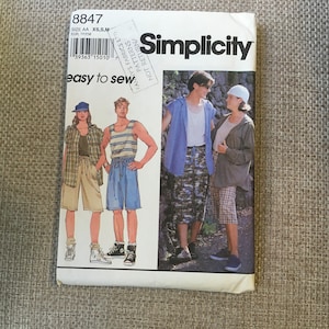 May include: A Simplicity sewing pattern with the number 8847. The pattern is for easy to sew clothing. The pattern shows three different outfits, two for men and one for women. The outfits are casual and include shorts, a tank top, a shirt, and a jacket.