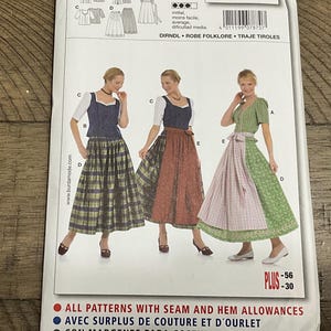 Könnte beinhalten: Eine Burda 7870 Schnittmusterhülle für ein Dirndl mit Abbildungen von drei Varianten des Kleides mit verschiedenen Oberteilen, Röcken und Schürzen. Der Text enthält "burda", "7870", "DIRNDL", "ROBE FOLKLORE", "TRAJE TIROLES" und "PLUS".