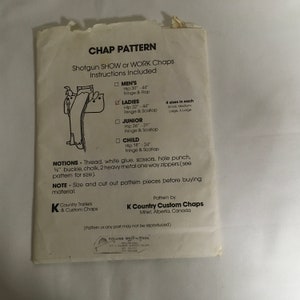 Op de afbeelding: Een wit papieren patroon voor het maken van chaps. Het patroon bevat instructies voor het maken van maten voor heren, dames, junioren en kinderen. Het patroon is voor shotgun show of werk chaps. Het patroon is van K Country Custom Chaps, Millet, Alberta, Canada.