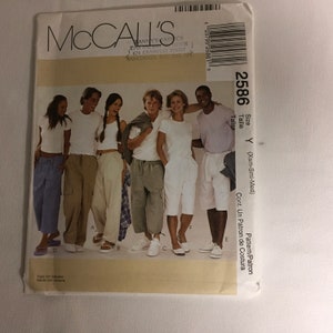 May include: A McCall's sewing pattern for a pair of pants. The pattern is for sizes X-Small, Small, and Medium. The pattern is shown on five people wearing different colored pants. The pattern is labeled "2586" and is for a "Cont. Un Patron de Costura" or "Pattern/Patron".