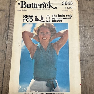 Op de afbeelding: Een vintage Butterick 3643 naaipatroon-envelop voor een wikkelblouse alleen voor breisels. De voorkant toont een foto van een persoon die een mouwloze, blauwgroene wikkeltop met een strikceintuur draagt, met de tekst Sew & Go en The knits only wraparound blouse.