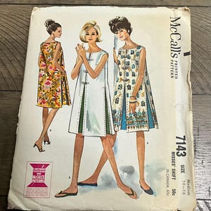 May include: Vintage McCall's sewing pattern for Misses' Shift dresses, size medium 14-16. The pattern envelope shows illustrations of three women in shift dresses with floral and geometric designs. The pattern number is 7143.