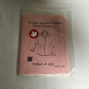 May include: A pink sewing pattern envelope with a drawing of a classic blouse and the text "Trudy Jansen Design Classic Blouse (easy) Pattern # 403 Sizes 6-20".