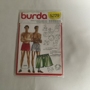 May include: A Burda sewing pattern package with the number 5229 printed on the front. The pattern is for men's underwear and includes 15 iron-on embroidery transfer motifs. The package shows two men wearing different styles of underwear.