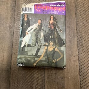 May include: Simplicity pattern for adult costumes. The pattern shows three women wearing different costumes. One woman is wearing a white coat, another is wearing a black leather jacket, and the third is wearing a black corset and pants.