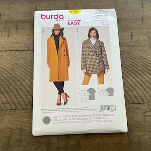 May include: A Burda Style sewing pattern envelope, number 6736, featuring two jacket and coat designs. View A shows a long mustard yellow coat, and View B shows a shorter, patterned tweed-style jacket. The envelope includes technical line drawings.