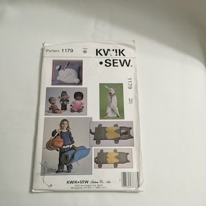 Könnte beinhalten: Ein Schnittmuster für ein graues Hasenkostüm, einen Schlafsack und ein Kissen. Das Schnittmuster ist von Kwik Sew Pattern Co., Inc. und trägt die Nummer 1179.