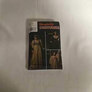 May include: Simplicity Costumes sewing pattern number 892 for a Renaissance era gown. The pattern shows three different styles of gowns with long sleeves and a fitted bodice. The gowns are shown in a variety of colors, including gold, red, and black.