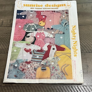 Könnte beinhalten: Ein Schnittmusterumschlag mit dem Titel Sunrise Designs Nighty Nights, der Illustrationen verschiedener Nachtwäsche für Säuglinge zeigt, darunter Strampler, Schlafanzüge und Lätzchen in rosa, blauen, gelben und grünen Mustern mit nummerierten Etiketten.