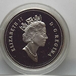 May include: Silver coin featuring a profile of Queen Elizabeth II with the inscription "ELIZABETH II D.G. REGINA" around the edge.