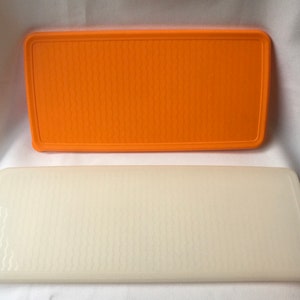 Peut inclure: Deux contenants en plastique rectangulaires avec une texture ondulée. Le conteneur supérieur est orange et le conteneur inférieur est blanc.
