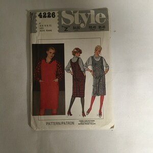 May include: A sewing pattern for a dress with three sizes: 8, 10, and 12. The pattern shows a red dress with pockets, a plaid dress, and a denim dress. The pattern is called "Style 4226".