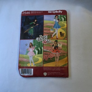 May include: Simplicity sewing pattern number 2546 for The Wizard of Oz costumes. The pattern includes four different costumes: the Wicked Witch of the West, Dorothy, the Tin Man, and the Cowardly Lion. The pattern is for sizes 8, 10, 12, 14, and 16.