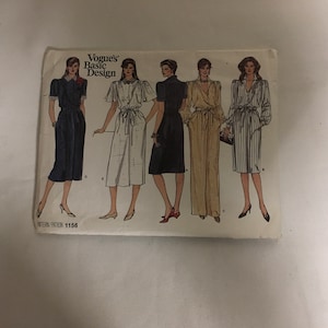 May include: Vogue's Basic Design sewing pattern number 1156. The pattern shows five different styles of dresses and jumpsuits. The dresses are in navy blue, white, and black. The jumpsuit is in a beige color with a pattern. The pattern is on a white background.