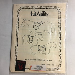 May include: A clear plastic package containing a pattern for multi-purpose saddle pads. The pattern features illustrations of horses with saddle pads and the text "SuitAbility". The package includes the text "Saddle Sizes 15-18".